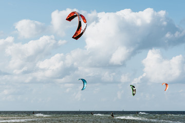 Kitesurfers are riding the waves of the Kieler Förde in the evening sun