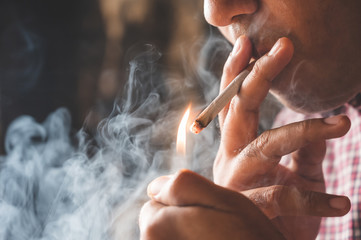 Close up young man smoking a cigarette.