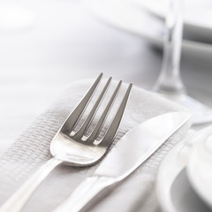 Close up of Silver fork and knife withnapkin  and glass . Restaurant dinning concept.