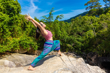 Naklejka premium Asian Thai woman practicing yoga on the top of a rock in Koh Phangan island, Thailand