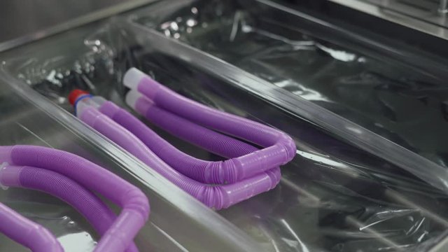 Production of medical oxygen equipment, woman at work, the process of packaging plastic tubes for breathing equipment.