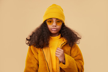 Serious hipster girl in warm clothes looking at camera