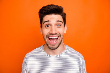 Closeup photo of crazy funky energetic guy open mouth best excited feelings emotions listen good news wear casual striped t-shirt isolated bright orange color background