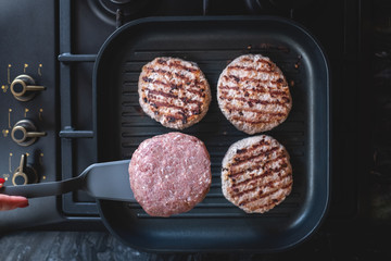 Fresh meat cutlets in a grill pan. Juicy meat steak in a pan. Cooking a burger at home. Delicious and healthy food concept.