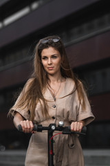 Fototapeta na wymiar beautiful girl riding an electric scooter in the city