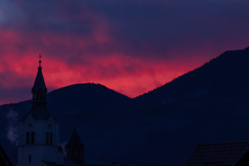 Pink sunlit sky over church in Bohinjska Bistrica