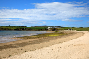 Orkney (Scotland), UK - August 06, 2018: Scapa Bay near Kirkwall in Orkney with the Scapa distillery buildings sitting above the shoreline in the distance, Orkney, Scotland, Highlands, United Kingdom