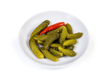 Pickled gherkins on the white saucer on a white background