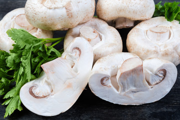 Whole and halves of uncooked button mushrooms among the parsley