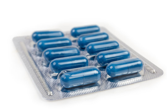 Blister pack with blue pills, close-up in selective focus