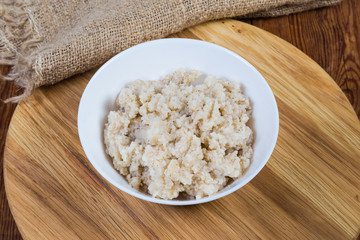 Barley porridge in bowl on the wooden serving board