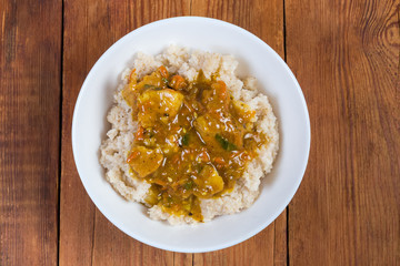 Top view of barley porridge with meat sauce in bowl
