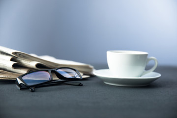 newspaper with coffee and glasses