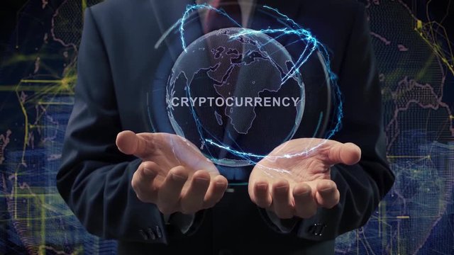 Male hands activate a conceptual holographic text Cryptocurrency. Businessman in a suit with a hologram of planet Earth on a background of a futuristic wireframe city