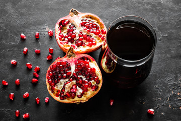 fresh pomegranate juice and pomegranate slices on a black background close-up