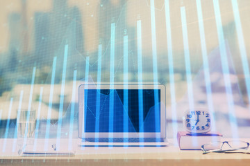 Forex graph hologram on table with computer background. Multi exposure. Concept of financial markets.