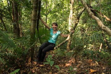 Naklejka na ściany i meble A girl swinging on a liana in the jungle, Koh Chang Island, Thailand