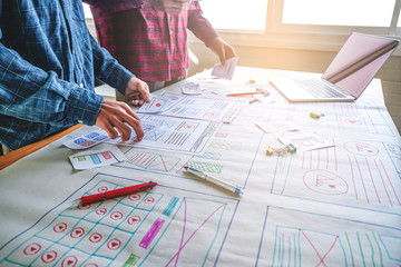 close up male asian ui/ux designers working and designing a user interface for website and...