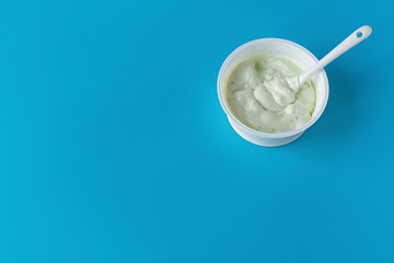 Yogurt in a glass on a blue background. A wholesome light diet breakfast. Dairy products.