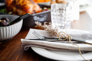 Black styled cutlery decorated with dried grass on a linen. The concept of celebrate event or...