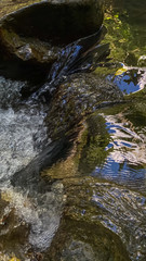 Water flows through rocks. Vertical background