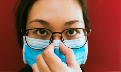 Asian Woman adjusting her Mask against Coronavirus