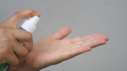 Female Uses Hand Sanitizer. Close up. Antiseptic spray protect from the virus.