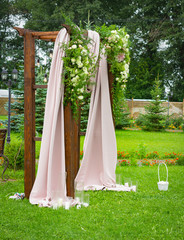 Wooden wedding arch outdoors. Away wedding ceremony.