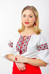 Isolated portrait of a beautiful girl in an embroidered blouse. Young woman with red lips in a red skirt.