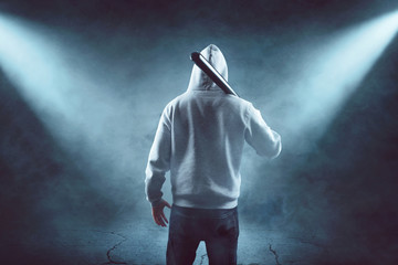 Mann mit Kapuzenpullover und Baseballschläger