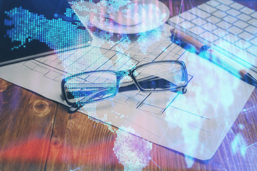 Financial chart hologram with glasses on the table background. Concept of business. Double exposure.