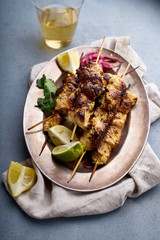 Chicken tikka kebab with marinated onion, fresh salad and yoghurt sauce. Traditional indian cuisine, delicious starter. Creative flatlay