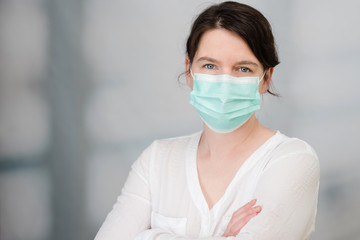 Frau mit medizinischem Mundschutz als Schutz vor Viren und Bakterien Covid-19 Coronavirus Maßnahmen, Klinikpersonal mit Mundschutz