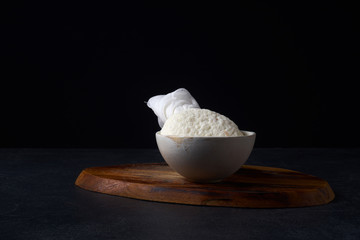 Traditional indian cheese paneer. Cooking vegetarian soft cheese in cheesecloth at home. Dark background, copy space
