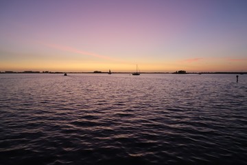 Sunset causing purple and orange glow in sky and water