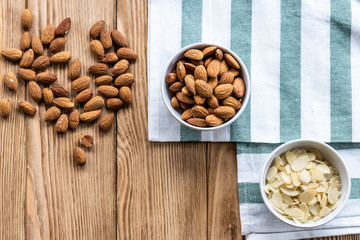  nuts in bowl on a wooden background. Rustic style. Almonds on a towel. Vegetarian food.