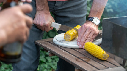 Man cutting corn in a garden