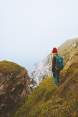 Obraz premium Woman traveler with backpack standing alone outdoor summer vacations travel adventure lifestyle isolation solo trip concept foggy sea landscape in Norway