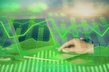 Double exposure of stock market graph with man working on laptop on background. Concept of financial analysis. © peshkova