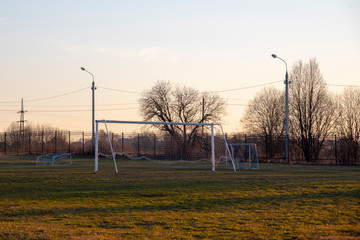 Fototapeta na wymiar Soccer goal on an empty field in the evening sun