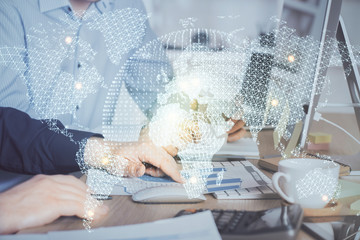 Double exposure of businessman working on laptop on background. International business hologram in front. Concept of success.