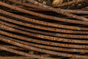 Rusty surface of iron wire macro photo. Abstract grunge background in red-brown color coiled rusty wire.