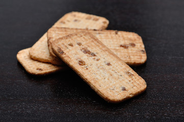 A pile of golden brown biscuits on a wooden background