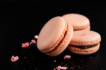 Macaroons on a black background. Sweet pastries.