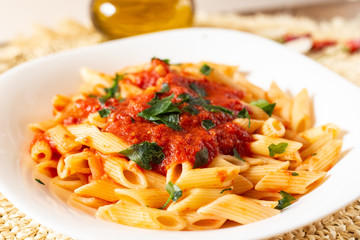 Penne pasta with tomato sauce. Traditional Italian dish, pasta with chili sauce. Italian food.