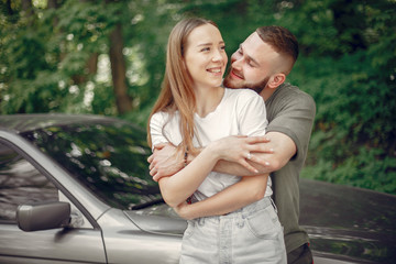 Couple in a forest. Man in a green t-shirt. Pair near car