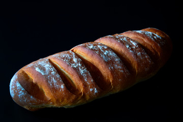 Fresh baked bread on a black background.