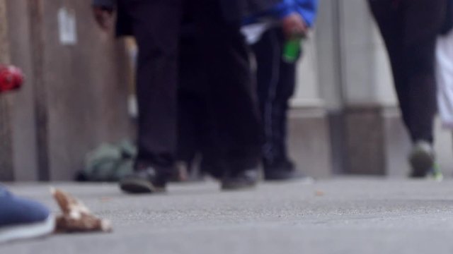 People walk on the street, close up to feet, shoes, boots, sneakers. Day time, busy street. Spring time.