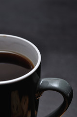 A close up of a gray mug filled with black coffee