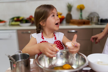 Little girl cooking with her mom